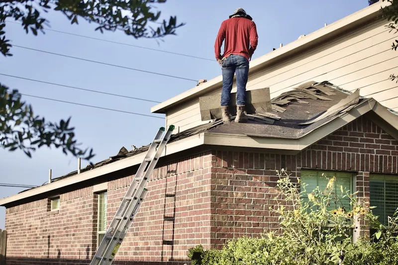 Professional roofer working on a residential roof in Dams Corner